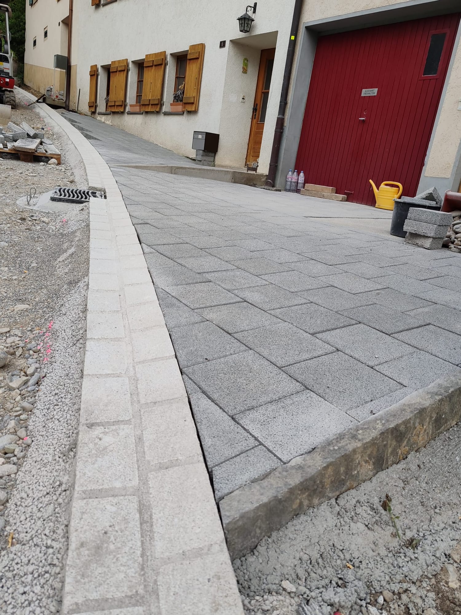 Neue Garageneinfahrt aus Sickerverbundsteinen mit Granit-Randstein im Fricktal