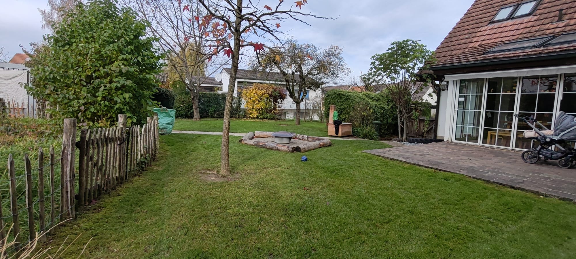 Familiengarten mit Rasen, Sandkiste und altem Baum
