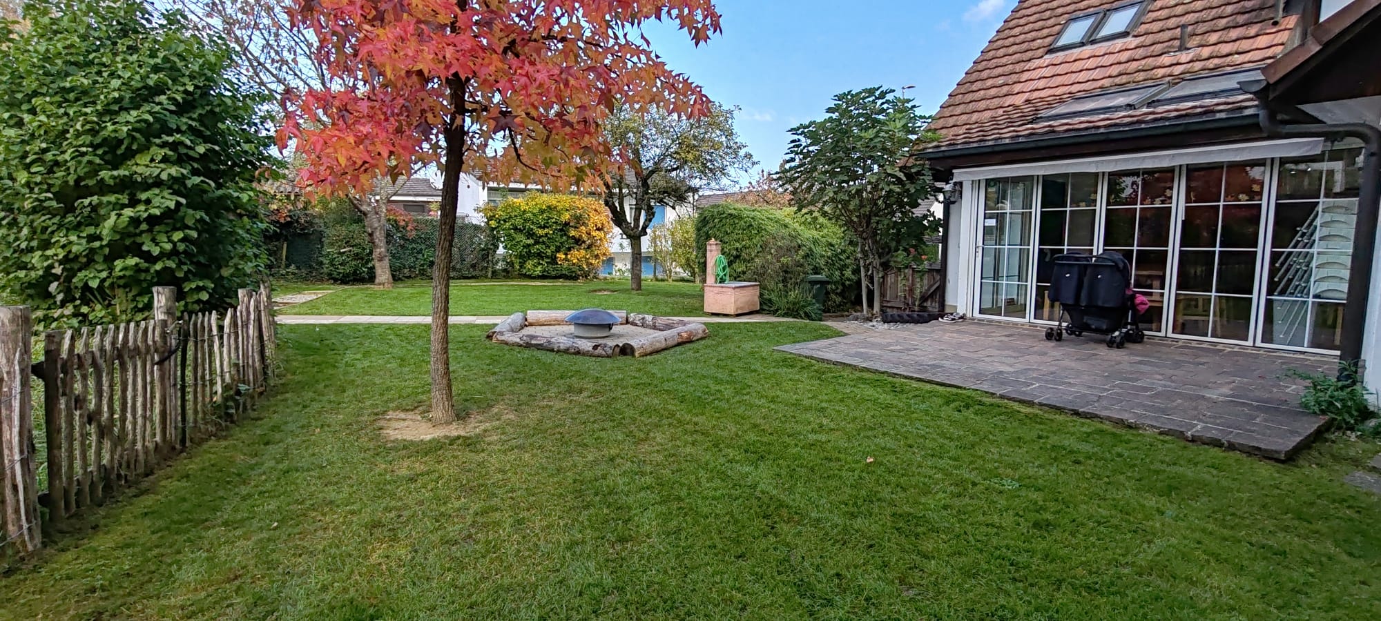 Privater Garten mit gepflegter Rasenfläche und Holzdeck